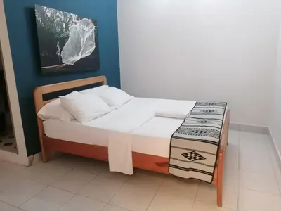 a small bed with a bench in a room at Hotel Casa de las Dos Palmas -Hotel Boutique in Puerto Berrío