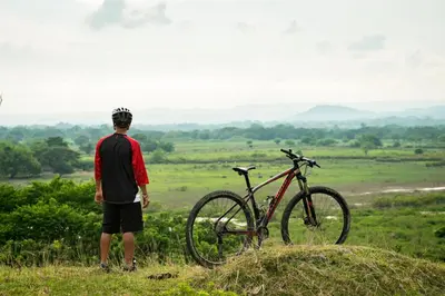 a man standing next to a bike on a hill at Hotel Casa de las Dos Palmas -Hotel Boutique in Puerto Berrío