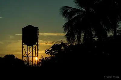 a silhouette of a water tower at sunset at Hotel Casa de las Dos Palmas -Hotel Boutique in Puerto Berrío