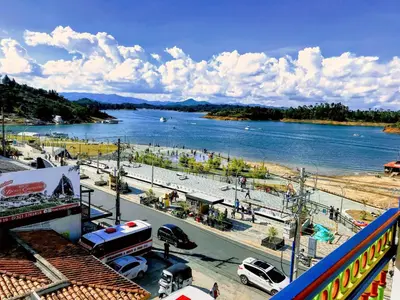 a view of a river with cars parked on a street at Aptos Plaza Principal, con y sin Vista al Embalse, frente Autobús, a 8 minutos de la Piedra del Peñol, TODO CERCA!!! in Guatapé