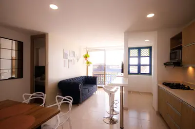 a kitchen and living room with a couch and a table at Aptos Plaza Principal, con y sin Vista al Embalse, frente Autobús, a 8 minutos de la Piedra del Peñol, TODO CERCA!!! in Guatapé