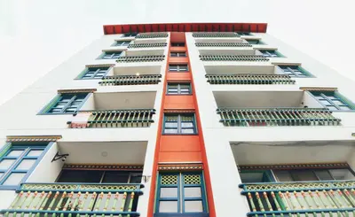 a tall white building with windows and balconies at Aptos Plaza Principal, con y sin Vista al Embalse, frente Autobús, a 8 minutos de la Piedra del Peñol, TODO CERCA!!! in Guatapé