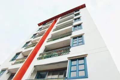 a white building with blue windows and balconies at Aptos Plaza Principal, con y sin Vista al Embalse, frente Autobús, a 8 minutos de la Piedra del Peñol, TODO CERCA!!! in Guatapé
