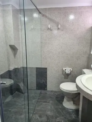 a bathroom with a toilet and a glass shower at Hotel Lukas in Medellín