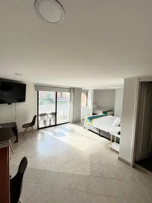 a bedroom with a bed and a flat screen tv at Hotel Lukas in Medellín