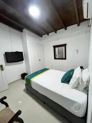 a large bed in a room with a tv at Hotel Lukas in Medellín