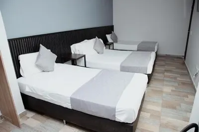 a couple of beds in a room at Hotel Palmas del Estadio in Medellín
