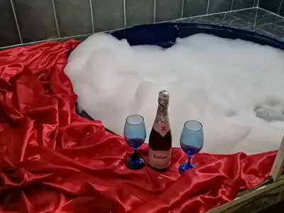a bottle of champagne and two wine glasses in a bath tub at Hotel Torreon De Rionegro in Rionegro