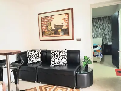 a black couch in a living room with a picture on the wall at New Cozy Apartment in the Poblado, San Lucas in Medellín