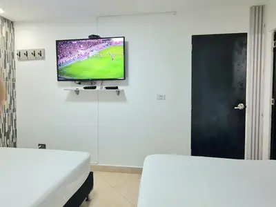 a room with a flat screen tv on a wall at New Cozy Apartment in the Poblado, San Lucas in Medellín