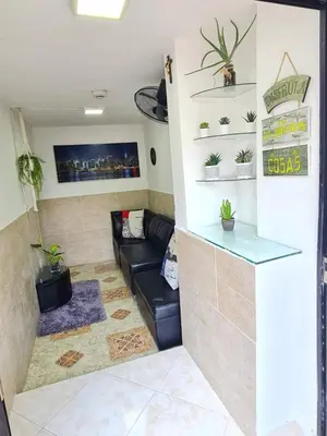 a living room with a black leather couch and plants at New Cozy Apartment in the Poblado, San Lucas in Medellín