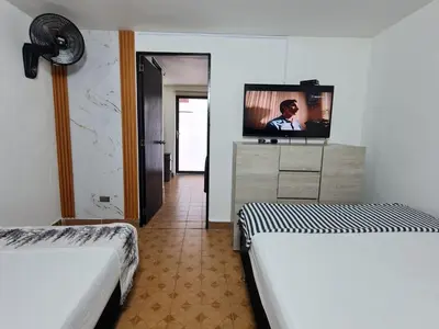 a hotel room with two beds and a flat screen tv at New Cozy Apartment in the Poblado, San Lucas in Medellín