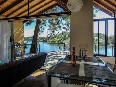 a view from the living room of a house with a table and chairs at Cottage on the Lake - Cabaña privada - Guatapé - Jacuzzi in Guatapé