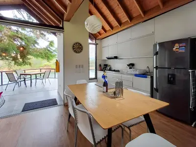 a kitchen with a wooden table and a refrigerator at Cottage on the Lake - Cabaña privada - Guatapé - Jacuzzi in Guatapé