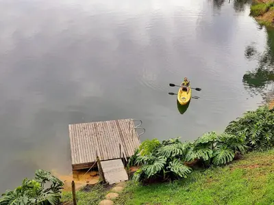 a person in a kayak in the water next to a dock at Cottage on the Lake - Cabaña privada - Guatapé - Jacuzzi in Guatapé