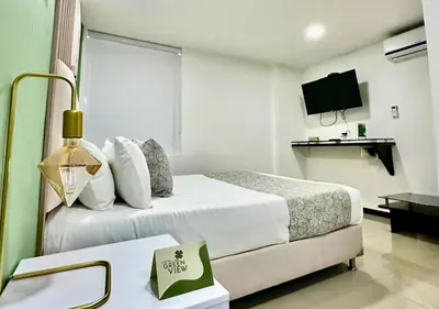 a hotel room with a large bed and a desk at Greenview Medellin By St Hoteles in Medellín