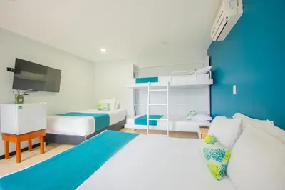 a bedroom with two beds and a blue wall at Greenview Medellin By St Hoteles in Medellín