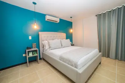 a bedroom with a bed and a blue wall at Greenview Medellin By St Hoteles in Medellín