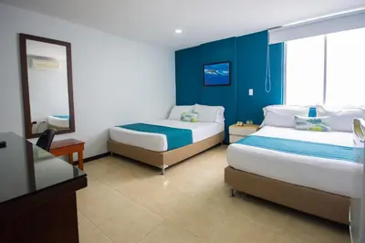 a bedroom with two beds and a blue wall at Greenview Medellin By St Hoteles in Medellín