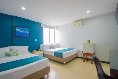 a hotel room with two beds and a desk at Greenview Medellin By St Hoteles in Medellín