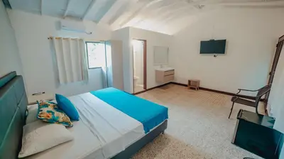 a bedroom with a large bed and a television at La Iguana de Santa Fe by Bernalo Hotels in Santa Fe de Antioquia