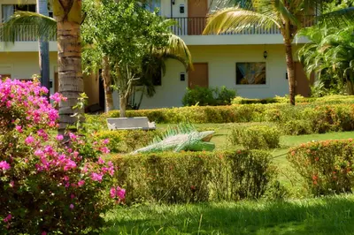 a garden in front of a house with pink flowers at La Iguana de Santa Fe by Bernalo Hotels in Santa Fe de Antioquia