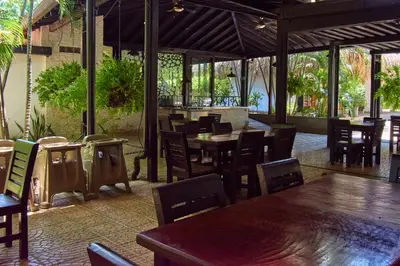 a restaurant with wooden tables and chairs and a bar at La Iguana de Santa Fe by Bernalo Hotels in Santa Fe de Antioquia