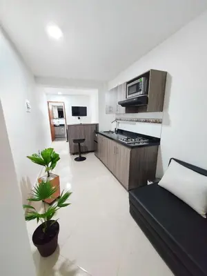 a living room with a couch and a kitchen at Apartaestudio Centro Comercial la Central in Medellín