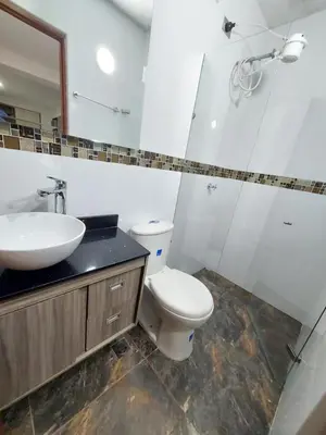 a bathroom with a toilet and a sink and a mirror at Apartaestudio Centro Comercial la Central in Medellín