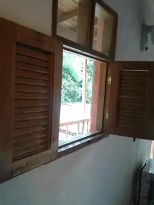 a window in a kitchen with wooden shutters at Selvablanca Hostel in San Jerónimo
