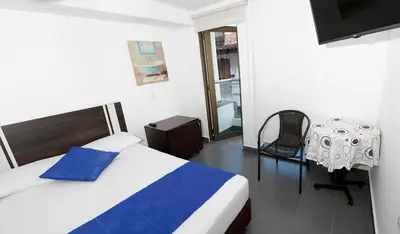 a bedroom with a bed and a table and a chair at Hotel San Fernandos Plaza in San Rafael
