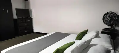 a bedroom with a bed and a dresser with a television at Hotel Premium Real in Medellín