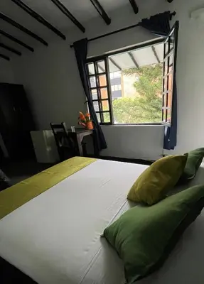 a bedroom with a large white bed with a window at Hotel Premium Real in Medellín