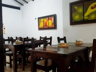 a dining room with wooden tables and chairs and a painting at Hotel Premium Real in Medellín