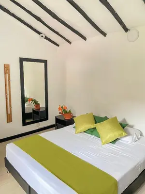 a bedroom with a bed with yellow pillows and a mirror at Hotel Premium Real in Medellín