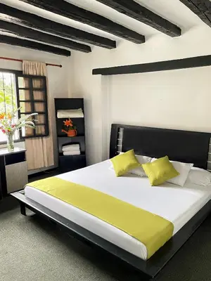 a bedroom with a large bed with yellow pillows at Hotel Premium Real in Medellín