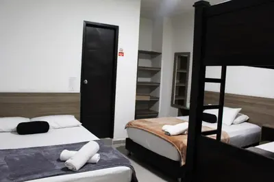 a bedroom with two beds and a bunk bed at Hotel America 52 in Rionegro