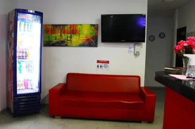 a room with a red chair and a television at Hotel America 52 in Rionegro