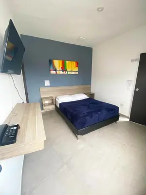 a bedroom with a bed and a desk with a computer at Hotel America 52 in Rionegro