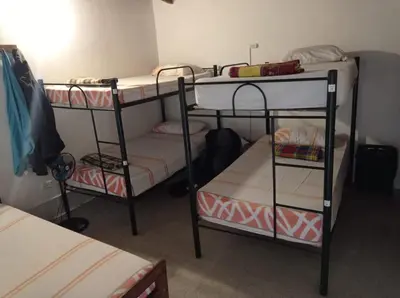 a room with three bunk beds in a room at Yellow House Hostel in Medellín
