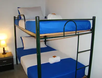 a bedroom with two bunk beds with blue sheets at Yellow House Hostel in Medellín