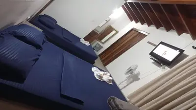 a bedroom with a blue bed and a television at Yellow House Hostel in Medellín