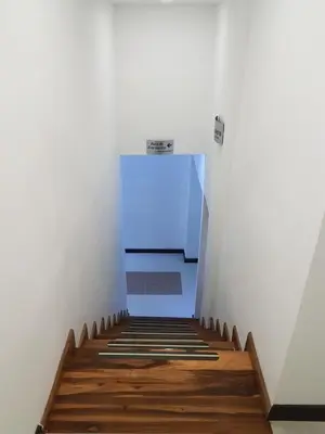 a hallway with a blue light at the end of a stairs at Hotel Orion in Chinchiná