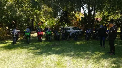 a group of people on motorcycles parked in the grass at Las Cabanas de Pino Hostel in Santa Fe de Antioquia