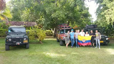 a group of people standing next to a truck with a flag at Las Cabanas de Pino Hostel in Santa Fe de Antioquia