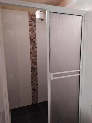 a shower with a sliding door in a bathroom at Hotel Orillas del Pizano in Jardin