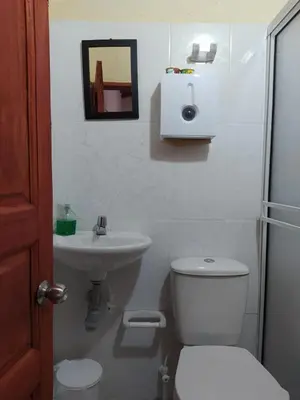 a bathroom with a toilet and a sink at Hotel Orillas del Pizano in Jardin
