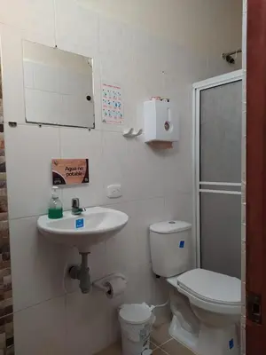 a bathroom with a toilet and a sink at Hotel Orillas del Pizano in Jardin