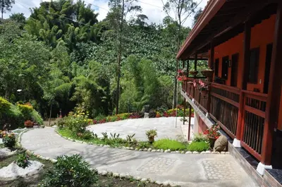 a walkway next to a building with flowers on it at Hotel Orillas del Pizano in Jardin