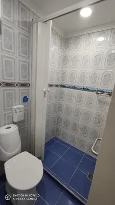 a bathroom with a toilet and a shower with blue tiles at Casa Hotel Manco Mora in Medellín